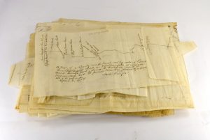 A stack of hand-drawn maps on tissue paper.